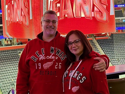 Jason Hededus and other person wearing Red Wings hoodies and standing in Little Caesars Arena