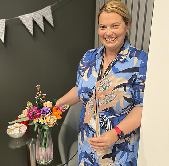 Svetlana Rajacic standing with flower arrangement made with LEGO®