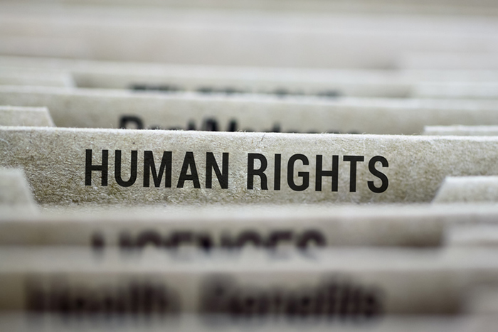 Aktenreiter mit der Aufschrift „Human Rights“ zwischen anderen Ordnern
