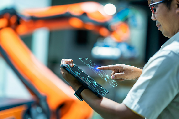 Senior engineer working on digital tablet and digitalization display in automated production area.